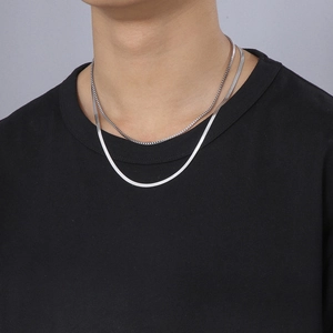Silver double layer necklace featuring flat snake chain and box chain on black shirt