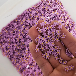 Macro shot of purple matte resin five-petal flower nail charms held in hand for DIY art