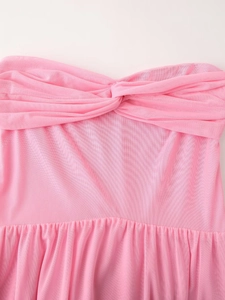 Detail view of the pink mesh tube dress featuring a twisted knot and pleated bodice