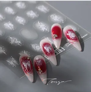 Detail of floral nail art stickers featuring white roses and butterflies on red nails