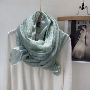 Detail of mint green lace linen scarf showing its soft texture and delicate floral edges