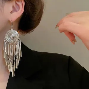 Vintage silver round earrings with long metal tassels shown on a model side profile