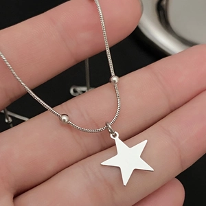 Close-up of silver liquid lava star pendant with snake chain on hand