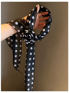 Detailed view of the fabric rose and polka dot pattern on the chiffon scarf necklace.