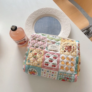 Detailed patchwork quilting and floral pattern on a soft cotton makeup storage bag