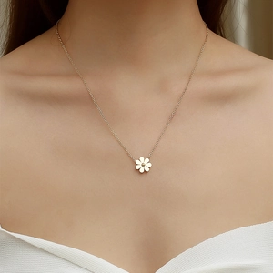 Chic golden stainless steel necklace with white daisy flower pendant on a model