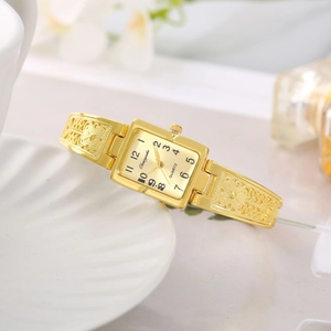Elegant gold square quartz bracelet watch for women with engraved metal band on white tray