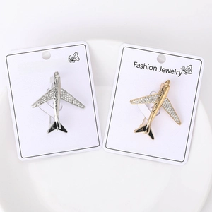 Macro detail of airplane brooch featuring crystal wings and Love You Forever engraving