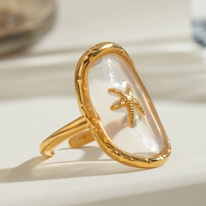 Macro shot of a starfish ring with a gold base and a transparent oval resin dome