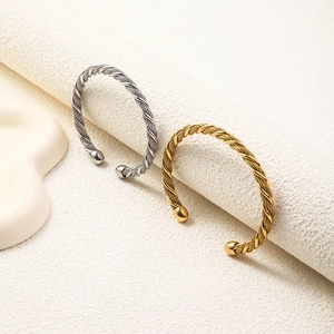Minimalist twisted cable open cuff bracelets in polished silver and gold finishes