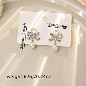 Detailed view of silver bow pearl earrings with dimensions 2.8cm height and weight 6.9g