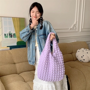 Detailed view of purple bubble textured knit fabric on a stylish shoulder tote bag