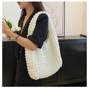 Detail of white seersucker textured large tote bag styled with a professional black blazer