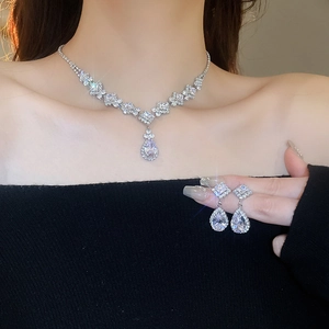 Close-up of model wearing silver teardrop zircon necklace and earrings jewelry set