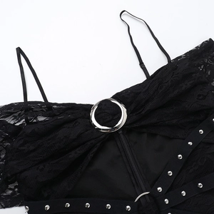 Dettaglio del vestito in pizzo nero con anello in metallo, cinturino con borchie e zip