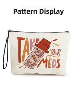 Close-up of canvas makeup bag featuring medicine bottle print and Take Your Meds slogan