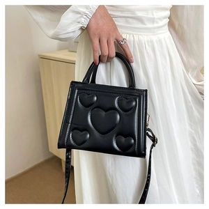 Détail du sac à main noir en PU avec gaufrage cœur et bandoulière amovible chic