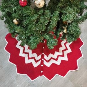 Detail of red and white knitted Christmas tree skirt with wavy patterns and button closure