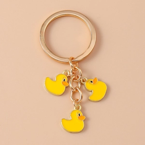 Detailed view of gold keychain featuring three cute yellow enamel duck pendants