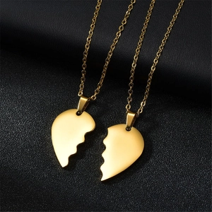 Close-up of gold stainless steel broken heart pendant necklace set for couples