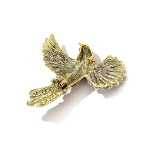 Vintage gold hummingbird brooch with crystal inlay and pin fastening on white background