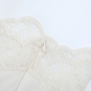 Macro detail of fine cream lace fabric with a concealed zipper on a knit dress