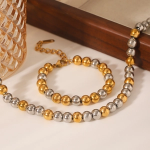 Détail de l'ensemble collier et bracelet bicolore en acier inoxydable doré et argenté