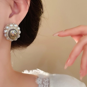 Close-up of retro silver stud earring featuring grey imitation pearl and rhinestone halo