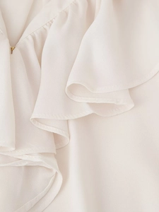 Detail view of elegant cream ruffled collar blouse with premium fabric texture