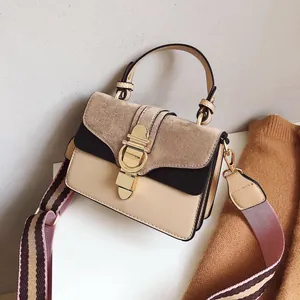 Detail of retro color-block square bag with gold ring lock and striped fabric strap