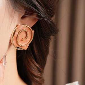 Macro detail of square vintage brown lacquer earring with gold spiral on model