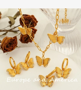 Detailed view of gold butterfly jewelry set featuring necklace and earrings with crystals