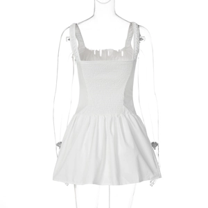 Detail of white mini dress featuring pleated waist and button accents on a mannequin