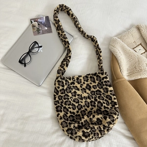 Detailed close-up of leopard print plush shoulder bag texture and soft faux fur material