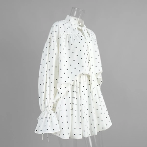Close-up of polka dot blouse with tie neck and matching mini skirt on a mannequin