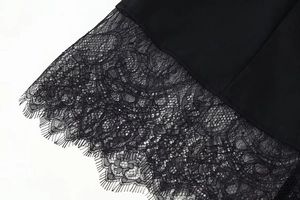 Close-up of the delicate eyelash lace trim on a black long-sleeved jacket for women