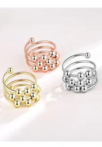 Detail of three rotating bead rings in gold, silver, and rose gold for anxiety relief