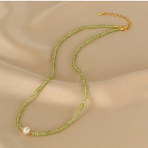 Double layer necklace with green peridot beads and a white freshwater pearl on gold chain