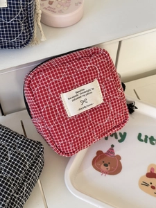 Detail of red checkered quilted pouch with heart pattern and zipper closure