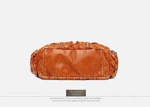 Detail view of the brown leather handbag base featuring reinforced stitching and soft texture