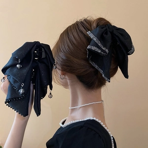 Detailed view of a black lace bow hair claw clip with sparkling rhinestones decoration