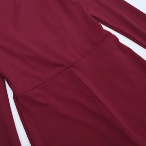 Vue détaillée du tissu en maille bordeaux avec coutures précises à la taille et poignets