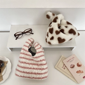 Gros plan de sacs à main en peluche à motif de cœur et de pochettes rayées douces