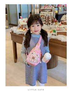 Pink child crossbody bag with cute Capybara print shown in a Christmas scene