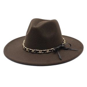 Detail of coffee wool fedora hat featuring a gold chain band with a black ribbon bow