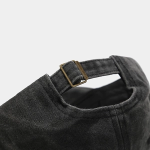 Detailed macro view of the vintage brass adjustable metal buckle on a washed cotton cap