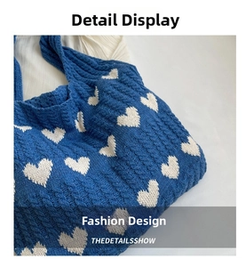 Close-up of cable knit pattern and heart embroidery on blue shoulder bag