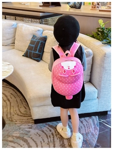 Pink strawberry rabbit backpack shown on a child in a cozy indoor setting