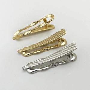 Close-up of geometric hollow twist and textured metal hair clips in gold and silver