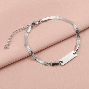 Macro shot of silver stainless steel herringbone chain bracelet with blank ID plate